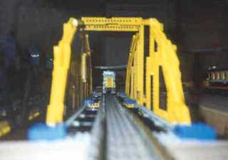 Looking down the yellow arch bridge as a locomotive starts across.